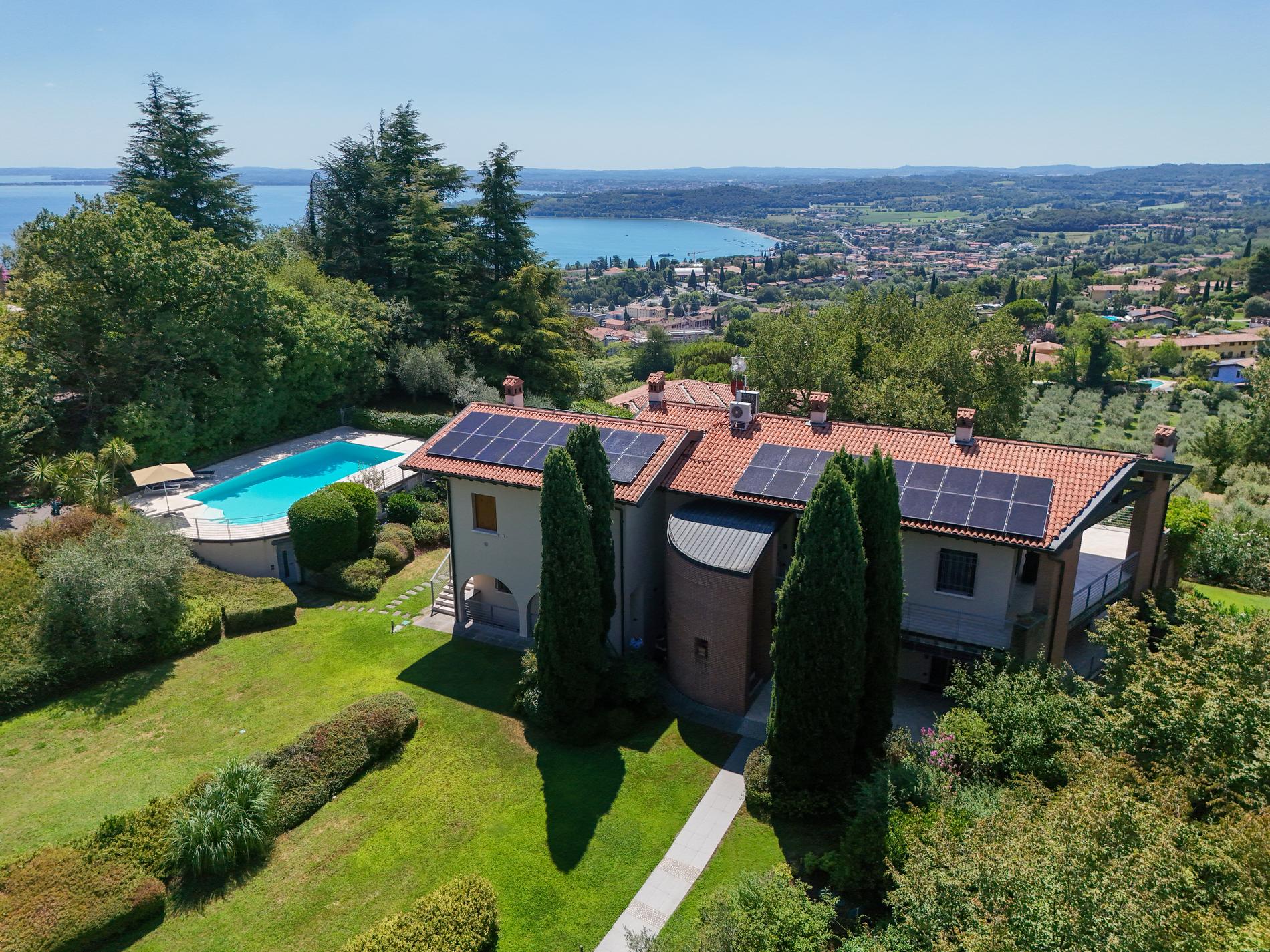 The villa and its pool on the hillside above Lake Garda