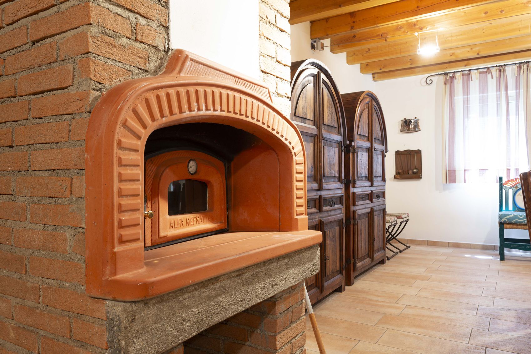 The wood-fired pizza oven built into the brick chimney breast
