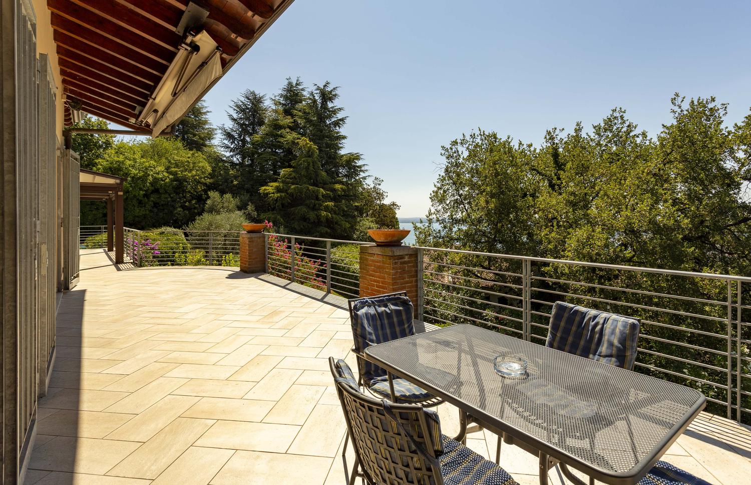 The terrace table under the awnings with the lake beyond
